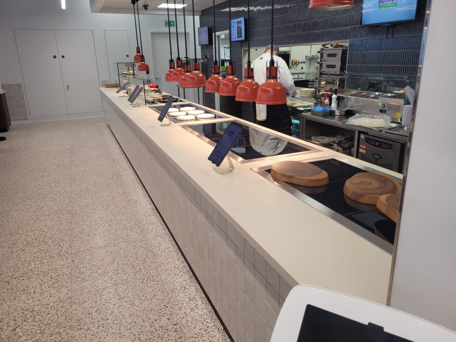 Custom-built service counter with engineered stone top and weatherboard frontage at Equinor's Paddington office, featuring designated areas for traditional plated service and live cooking.