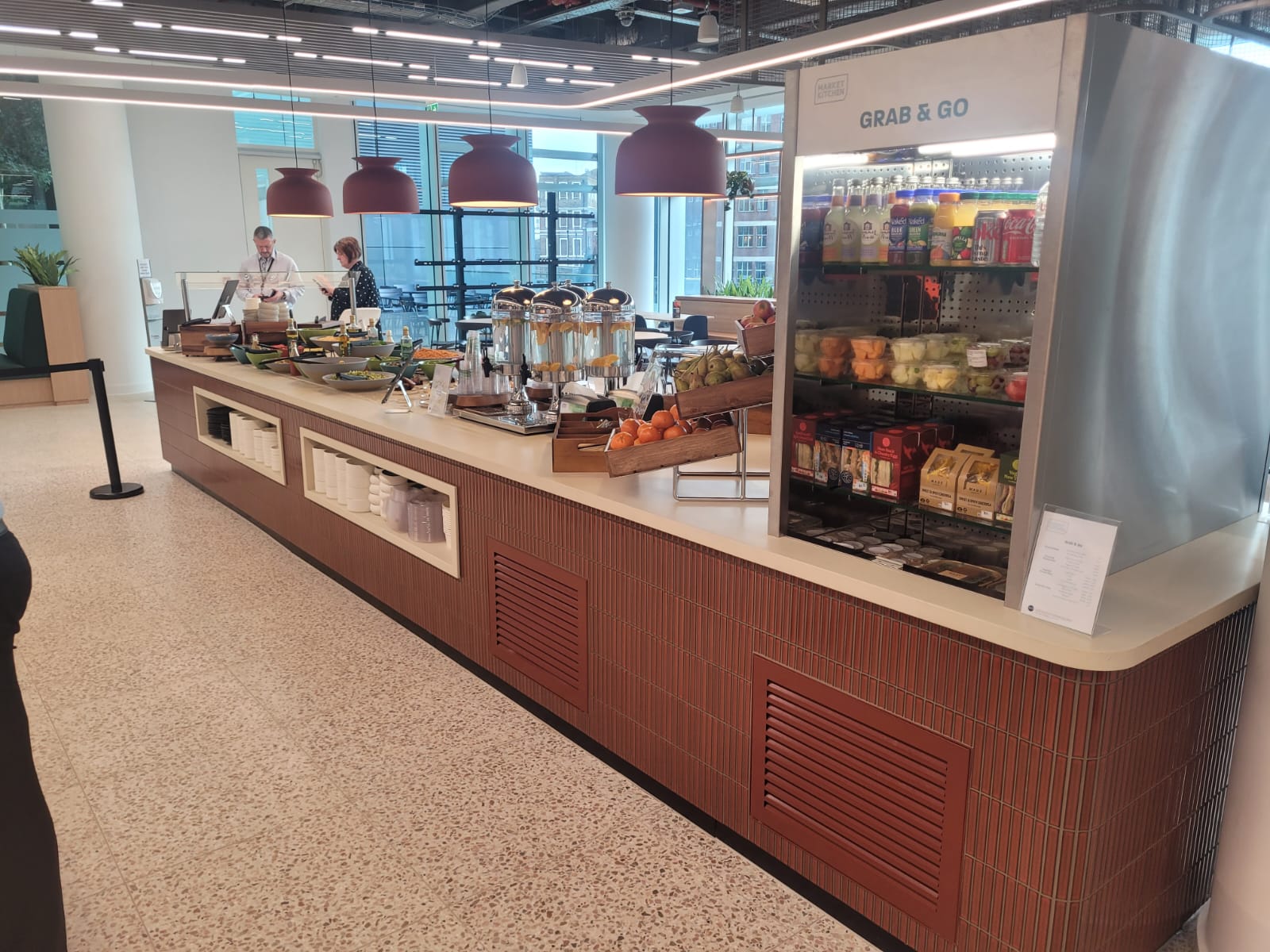 Custom-built service counter with engineered stone top and weatherboard frontage at Equinor's Paddington office, featuring designated areas for traditional plated service and live cooking.